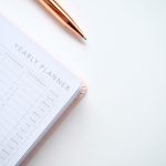 close-up-photo-of-yearly-planner-beside-a-pen-1558691