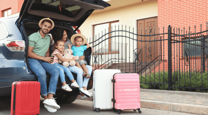 family sitting in trunk of car for road trip