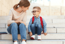 mom with son wearing backpack on steps