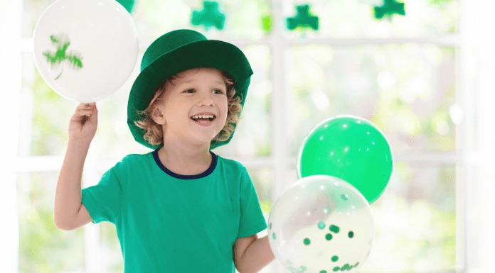 child celebrating st. patrick's day with balloons
