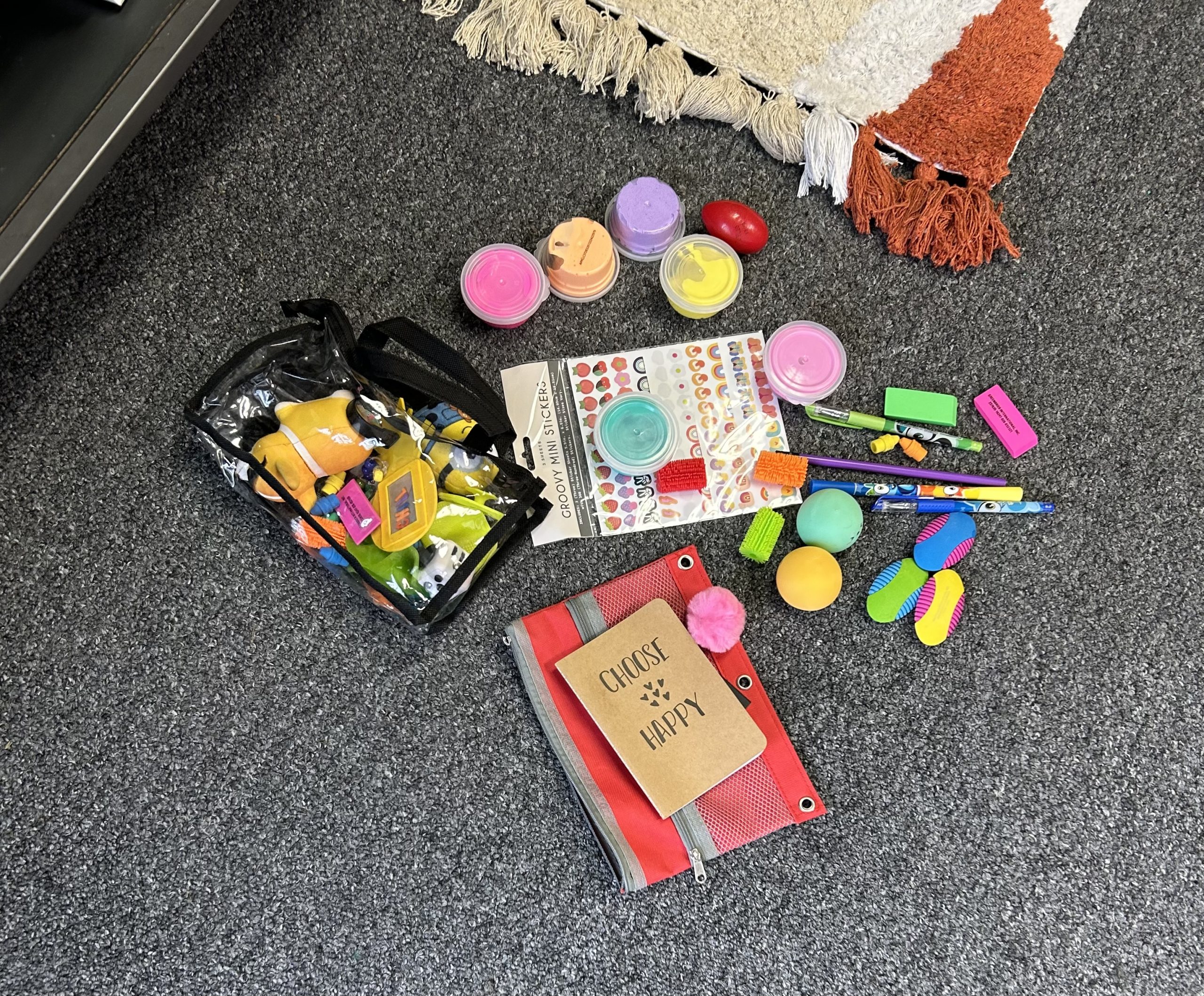 Piles of fidgets and sensory items such as pom poms, squishies, notebooks and scented pens