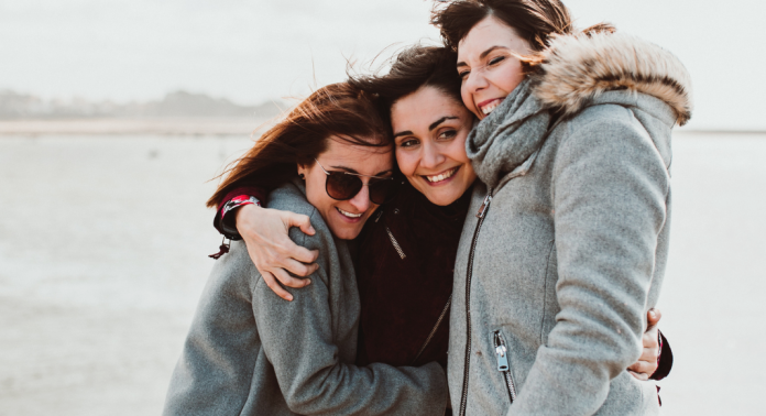 three female friends hugging and smiling